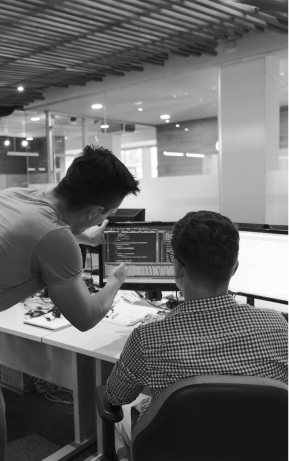 Duas pessoas do time da hzero trabalhando juntas em frente ao computador